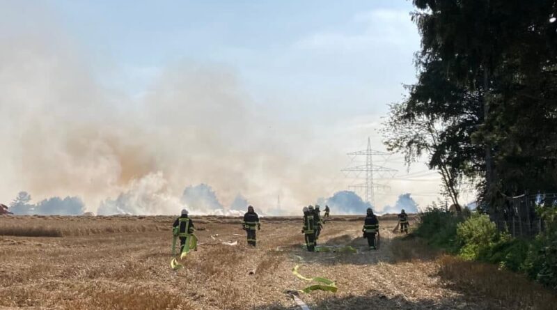 Die Feuerwehr im Einsatz. Im Hintergrund sieht man den Rauch aufsteigen.