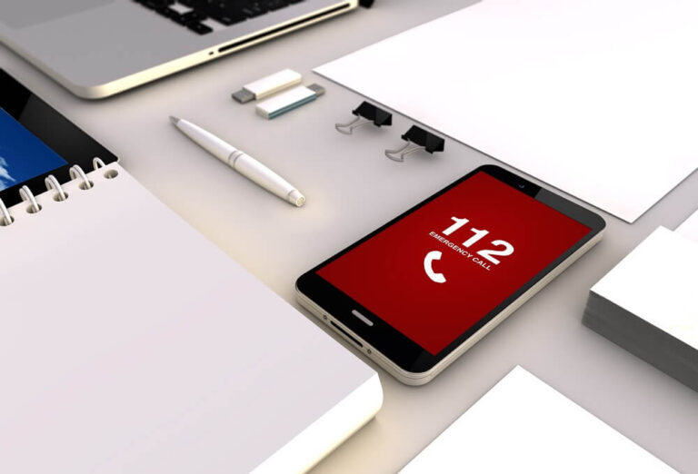 Handy mit Notrufnummer 112 liegt auf dem TIsch und setzt Fehlnotruf ab