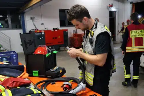 Feuerwehrmann prüft Generatorkabel