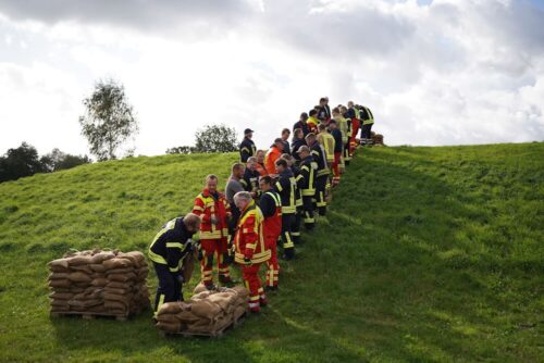 Kettenbildung: Transport von Sandsäcken auf den Deich. Foto: Carsten Schmidt