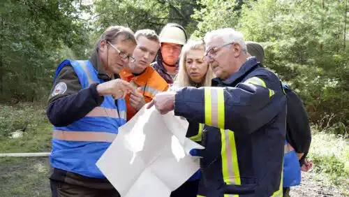 Arbeit im Team: Feuerwehrleute und Förster sprechen über die Einsatzmaßnahmen.