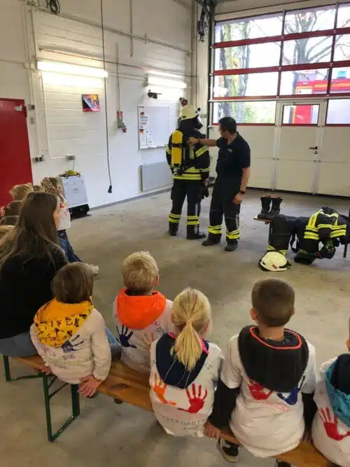 Keine Angst vor Feuerwehr-Montur. Die Kinder bekommen die Funktion der Kleidung erklärt.