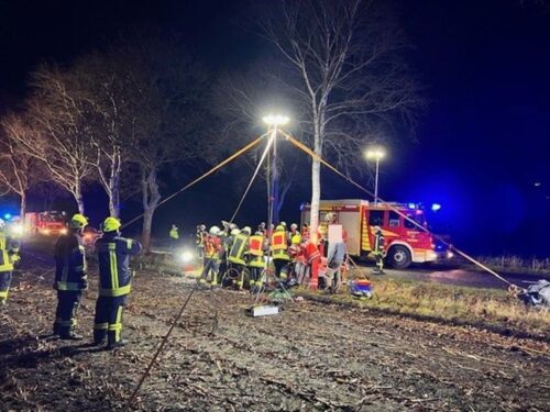 Die Einsatzkräfte bearbeiten den Pkw mit schwerem Gerät.