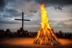 Großes Osterfeuer und Menschen drum herum