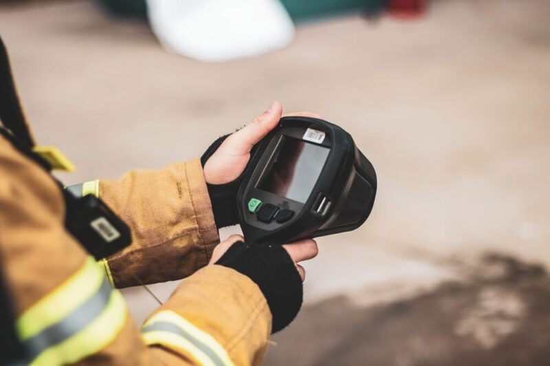 Feuerwehrmann hält eine Wärmebildkamera in der Hand