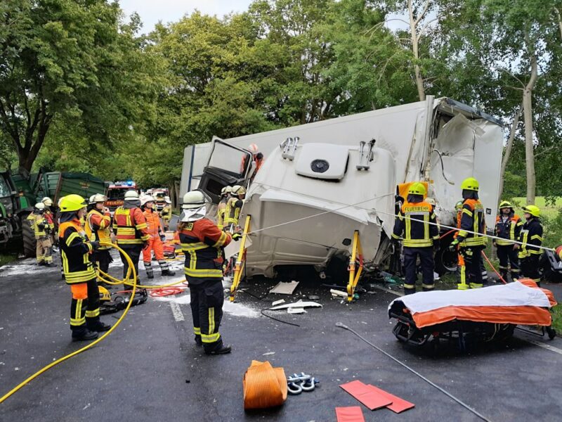 Nach dem Zusammenstoß mit einem Traktorgespann ist das Fahrerhaus eines Lkw komplett vom Fahrzeug abgerissen. Einsatzkräfte arbeiten am Lkw, um den eingeschlossenen Fahrer zu befreien. Foto: Kreisfeuerwehr Rotenburg (Wümme)