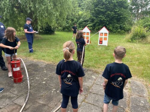 Brandbekämpfung: Die Aligser Feuerwehrspatzen „löschten“ die aufgemalten Flammen mit einer Kübelspritze. Wie im echten Einsatz war dabei Treffsicherheit gefragt. (Foto: Freiwillige Feuerwehr Lehrte)