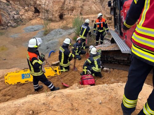 Abrutschen verhindern: Mit Keilen und Unterbaumaterialien wird der Bagger zunächst gesichert. Nach der Sicherung des Baggers mit den Seilwinden der Rüstwagen kann die verunfallte Person (Puppe) freigegraben und befreit werden. (Foto: Kreisfeuerwehr Rotenburg-Wümme)