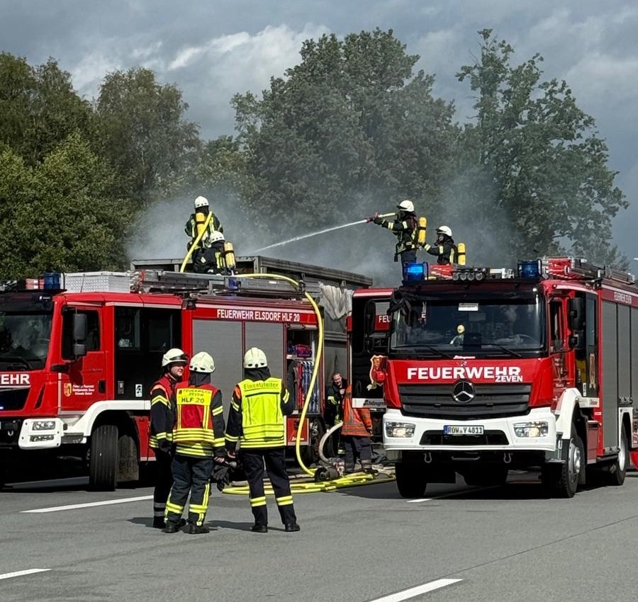 Brandbekämpfung: Die Feuerwehrkräfte löschten die Flammen zuerst mit Wasser über die Oberseite der transportierten Stahlmulde. (Foto: Kreisfeuerwehr Rotenburg (Wümme))